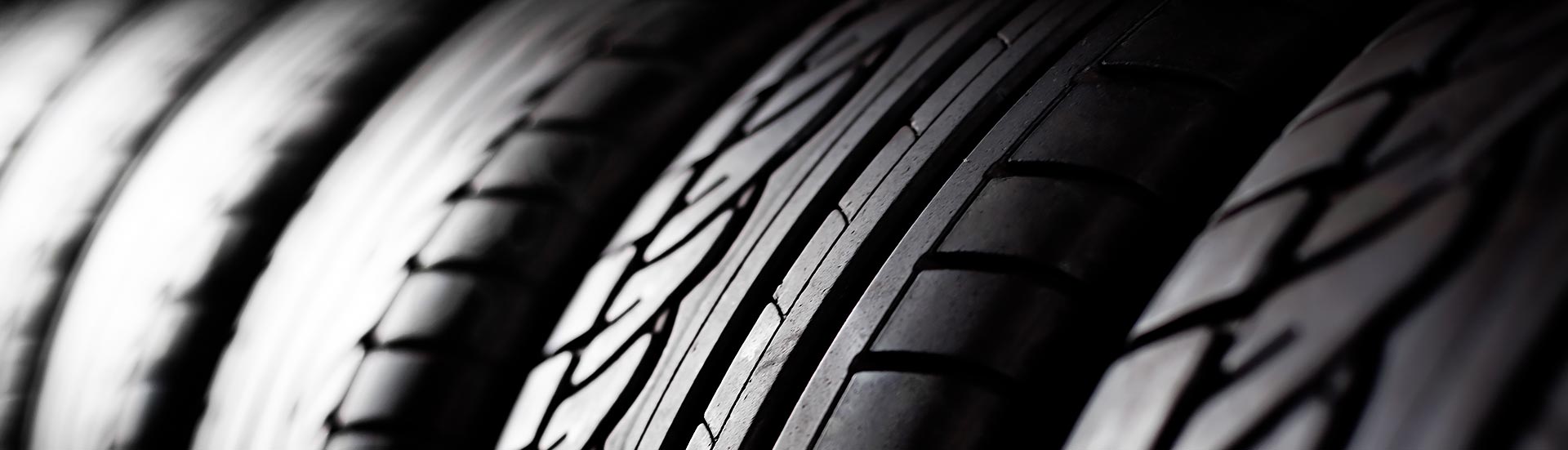 Close-up macro view of the treads on a row of new tires.