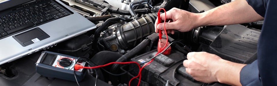 A man checking the car's voltage using a machine.