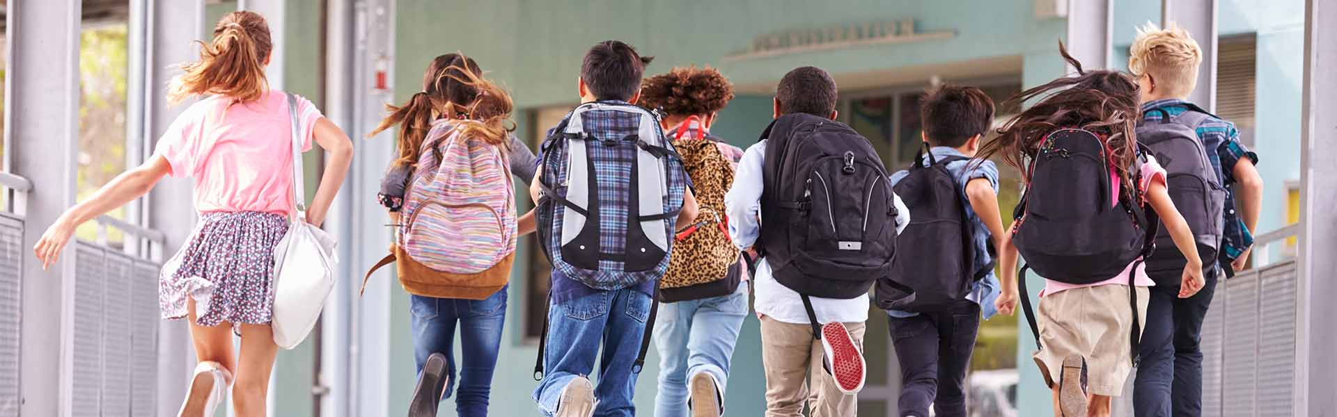 Students are running on the floor, carrying bags.